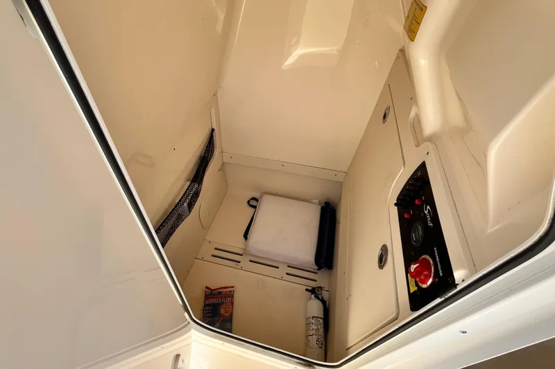 Slide: The Image of Interior storage compartment of 2021 Scout 215 XSF boat with safety equipment. - 30