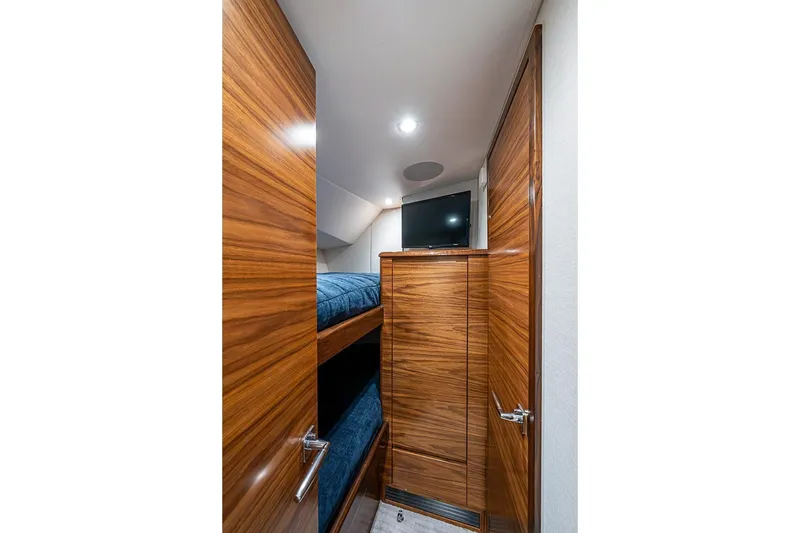 Slide: The Image of Interior of 2026 Viking 54 Convertible yacht with wooden finish and bunk beds. - 48
