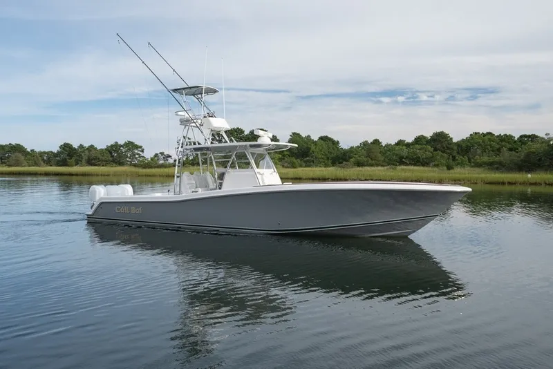 Slide: The Image of 2023 Invincible 39 Open Fisherman boat on calm water, surrounded by greenery. - 7