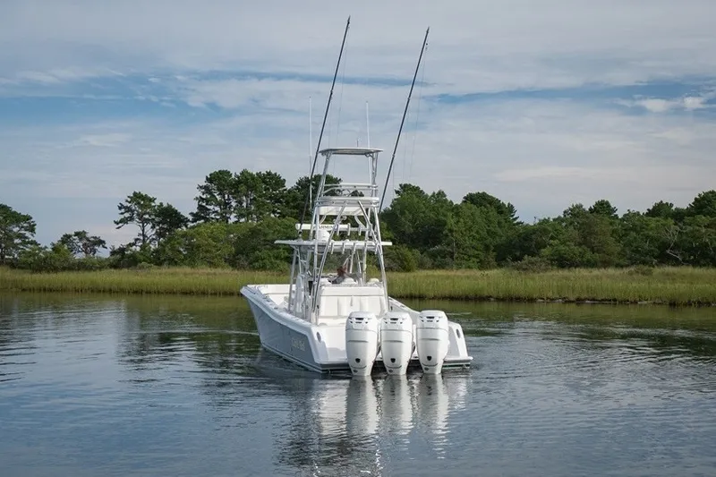 Slide: The Image of 2023 Invincible 39 Open Fisherman boat with triple engines on a calm waterway. - 2