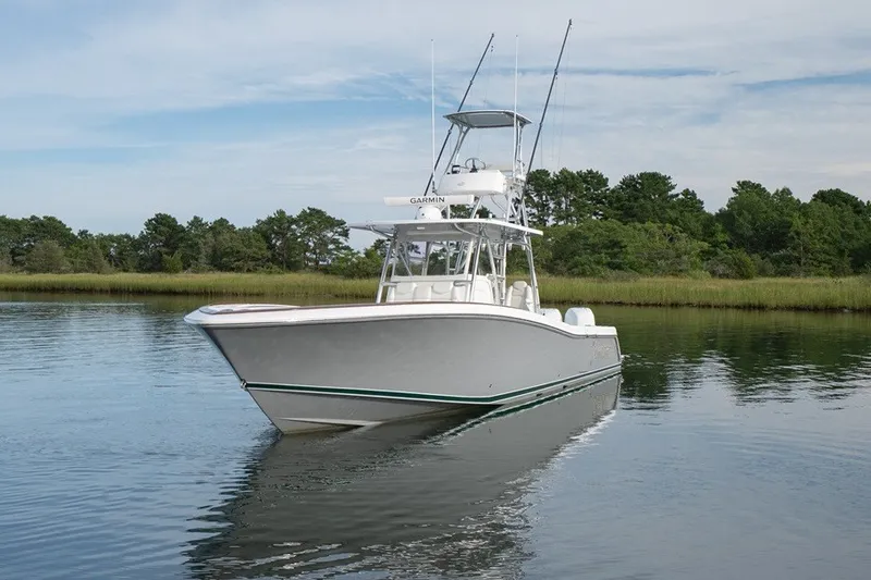 Slide: The Image of 2023 Invincible 39 Open Fisherman boat on calm water, surrounded by greenery. - 10