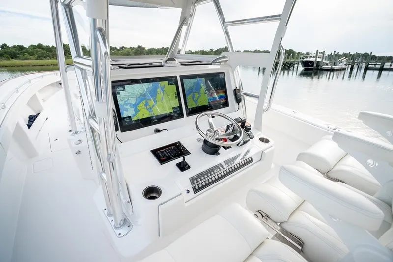 Slide: The Image of 2023 Invincible 39 Open Fisherman boat cockpit with dual navigation screens and plush seating. - 26