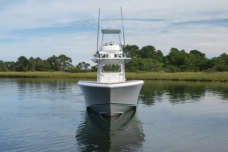 Slide: The Image of 2023 Invincible 39 Open Fisherman boat on calm water, surrounded by lush greenery. - 9