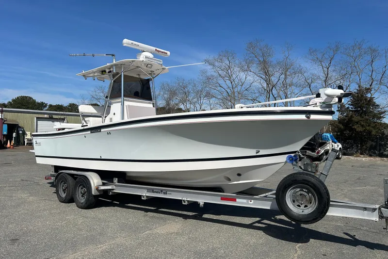 The Image of 2006 Albin 26 Center Console boat on trailer, parked outdoors under clear blue sky. - 0