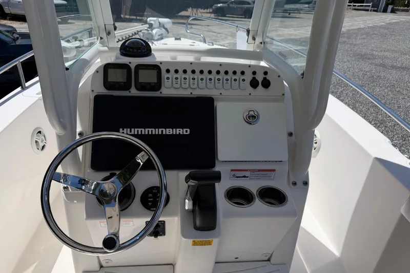 Slide: The Image of 2013 Everglades 210 Center Console boat dashboard with steering wheel and Humminbird display. - 16