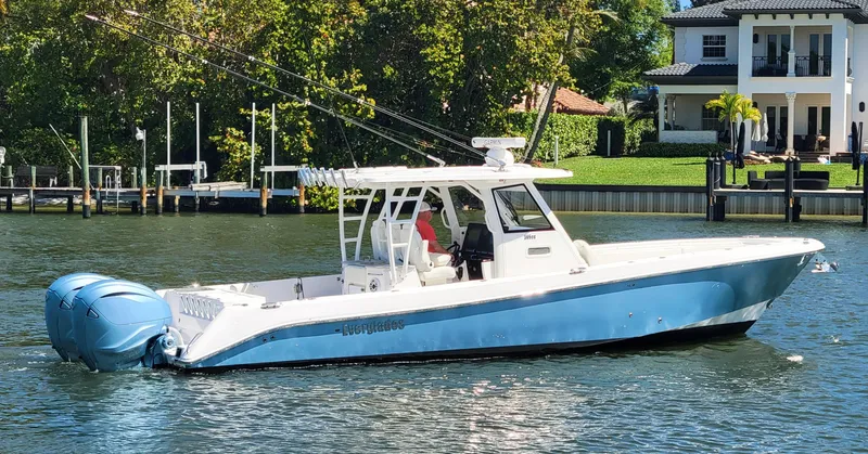 Slide: The Image of 2024 Everglades 365 Center Console boat on a calm river near waterfront homes. - 26