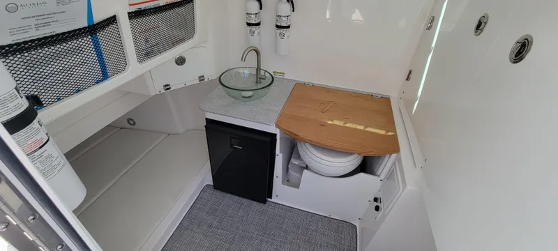 Slide: The Image of 2024 Everglades 365 Center Console interior with sink, toilet, and storage. - 23