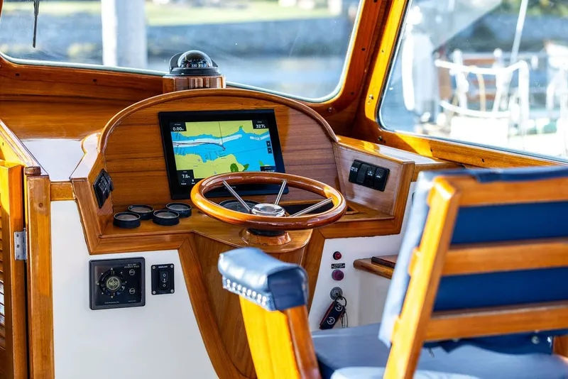 Slide: The Image of Hinckley Picnic Boat 36 Classic 1998 helm with wooden steering wheel and navigation display. - 28