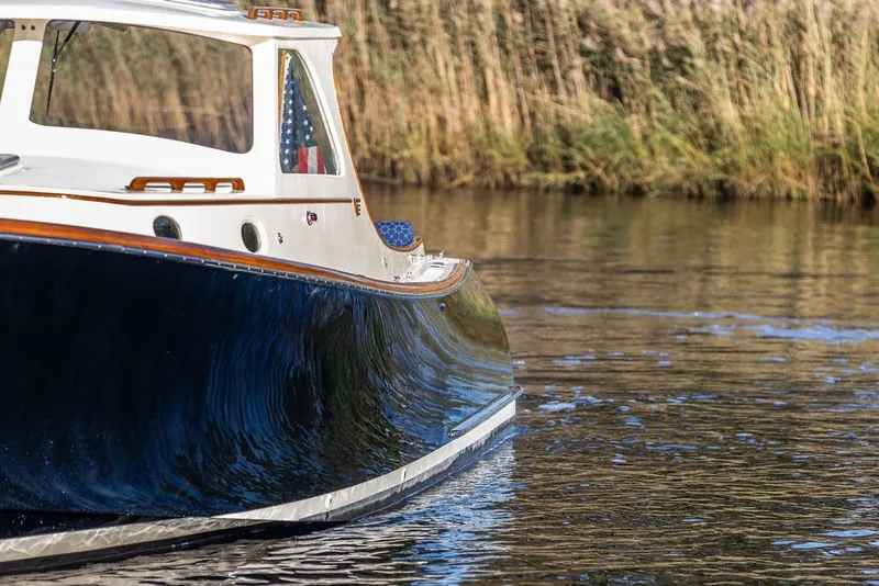 Slide: The Image of 1998 Hinckley Picnic Boat 36 Classic cruising on calm water near reeds. - 14