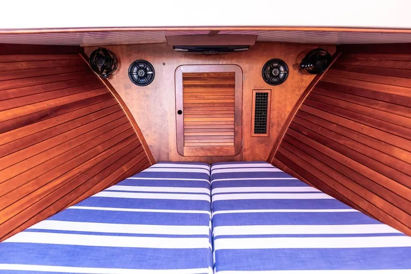 Slide: The Image of Interior cabin of 1998 Hinckley Picnic Boat 36 Classic with striped bedding and wooden paneling. - 44