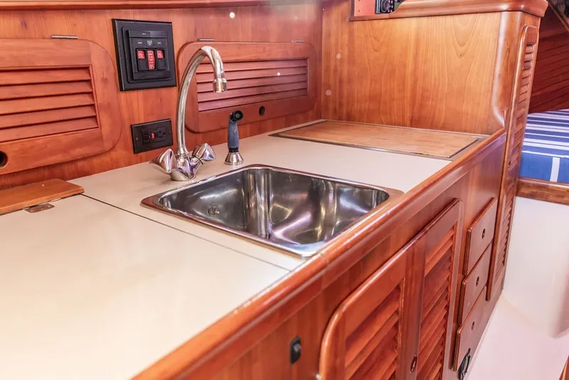 Slide: The Image of Hinckley Picnic Boat 36 Classic 1998 interior galley with sink and wooden cabinetry. - 47