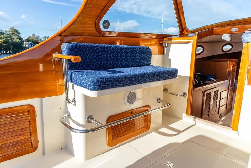 Slide: The Image of Interior of 1998 Hinckley Picnic Boat 36 Classic with blue cushioned seating and wooden accents. - 24