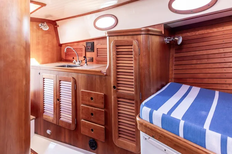 Slide: The Image of Interior of 1998 Hinckley Picnic Boat 36 Classic with wood cabinetry and striped seating. - 41