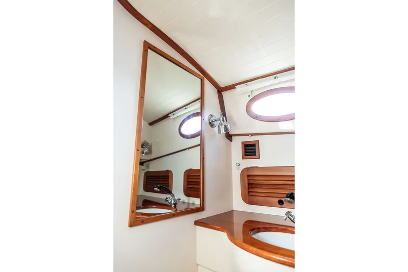 Slide: The Image of Interior of 1998 Hinckley Picnic Boat 36 Classic, featuring a wooden-framed mirror and porthole. - 52