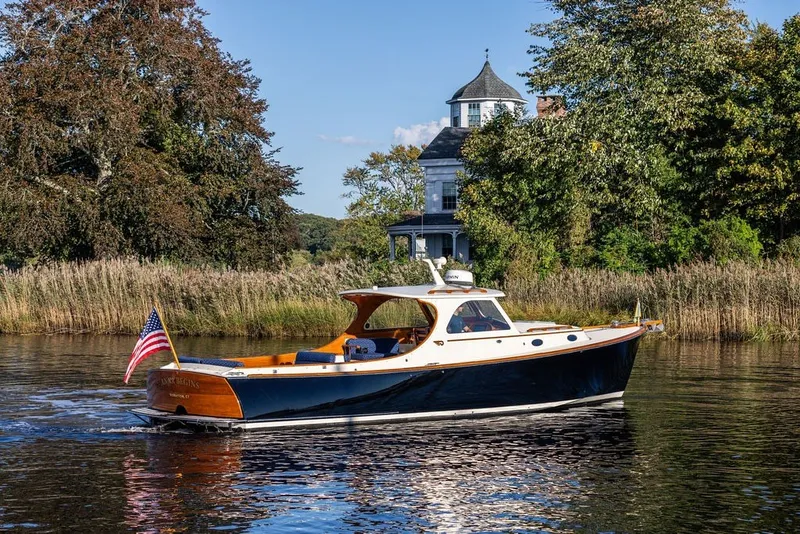 The Image of 1998 Hinckley Picnic Boat 36 Classic cruising on a scenic river near a historic house. - 0