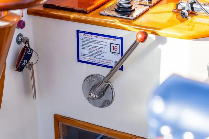 Slide: The Image of Control panel of a 1998 Hinckley Picnic Boat 36 Classic with emergency radio procedures. - 35