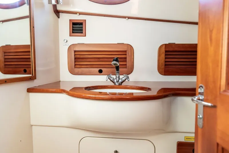 Slide: The Image of Elegant wooden vanity in 1998 Hinckley Picnic Boat 36 Classic bathroom. - 51