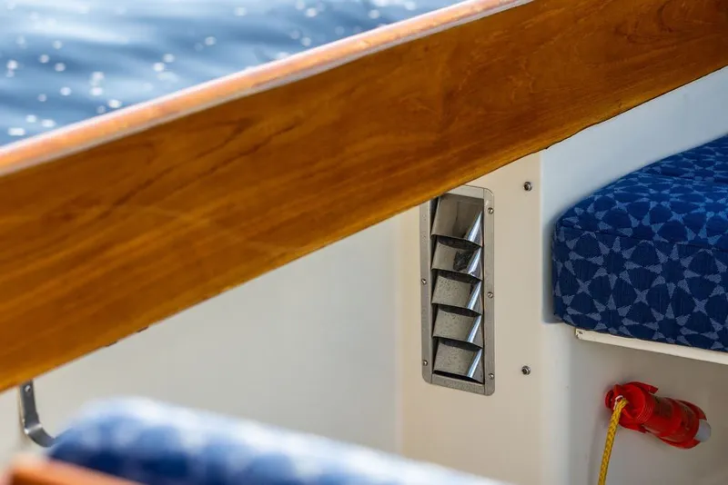 Slide: The Image of Interior detail of a 1998 Hinckley Picnic Boat 36 Classic, featuring wood trim and patterned seating. - 26