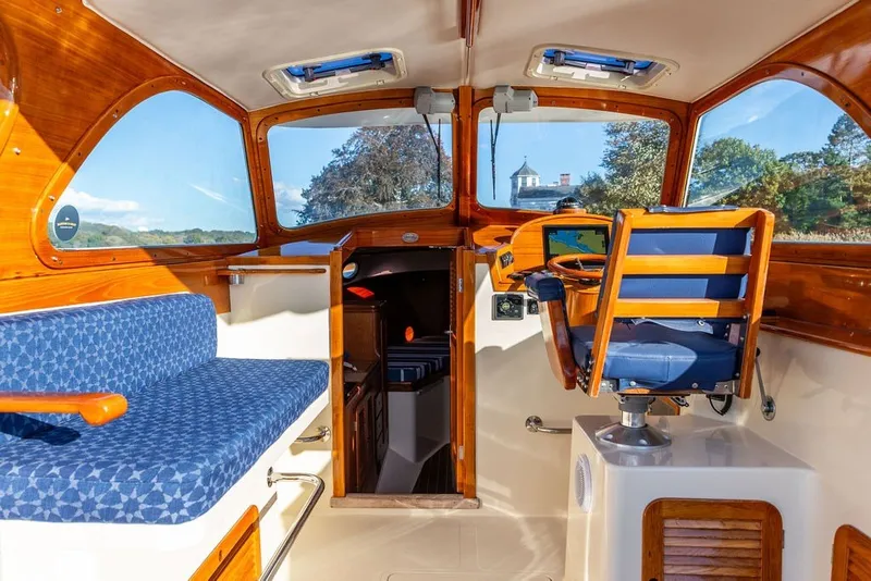 Slide: The Image of Interior of a 1998 Hinckley Picnic Boat 36 Classic with wooden accents and blue seating. - 21