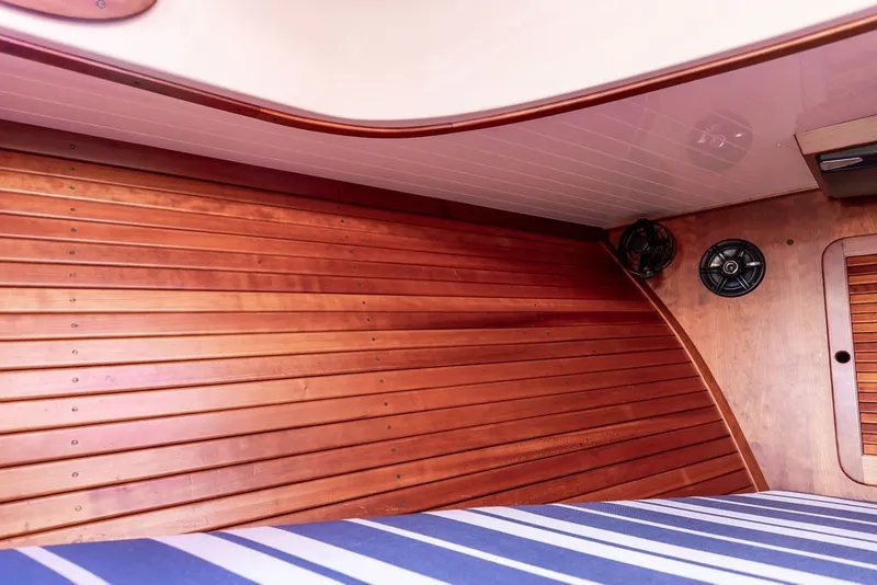 Slide: The Image of Interior of 1998 Hinckley Picnic Boat 36 Classic with wooden paneling and striped upholstery. - 48