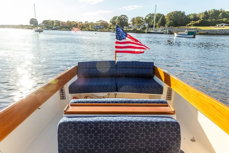 Slide: The Image of 1998 Hinckley Picnic Boat 36 Classic on serene water with American flag. - 23