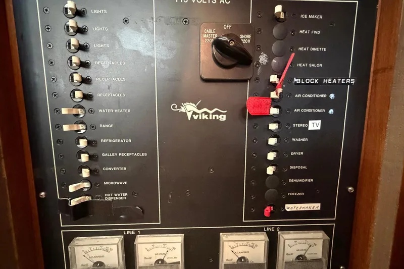 Slide: The Image of Control panel of a 1987 Viking 44 Motor Yacht with labeled switches and meters. - 83