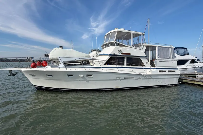 Slide: The Image of 1987 Viking 44 Motor Yacht docked on calm water under a clear blue sky. - 2