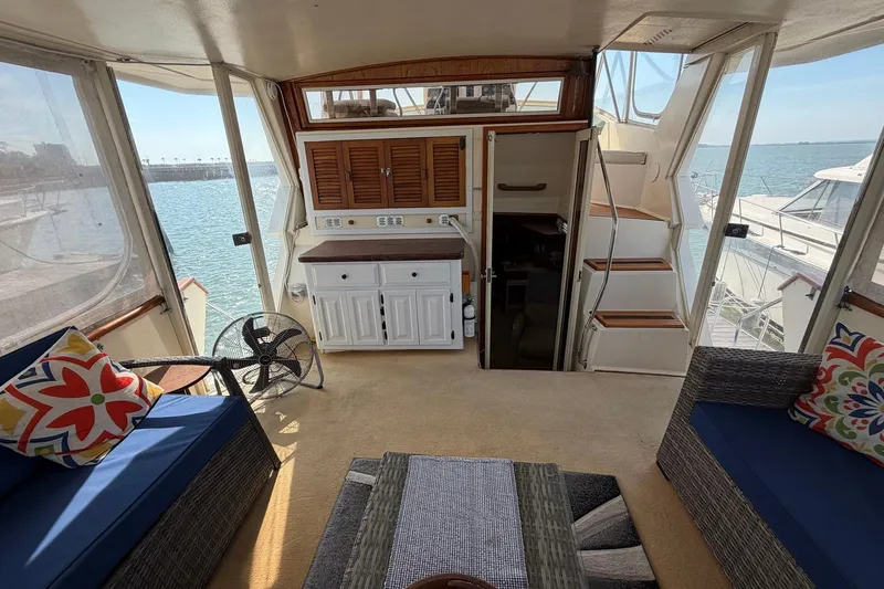 Slide: The Image of 1987 Viking 44 Motor Yacht interior with seating, fan, and ocean view. - 23