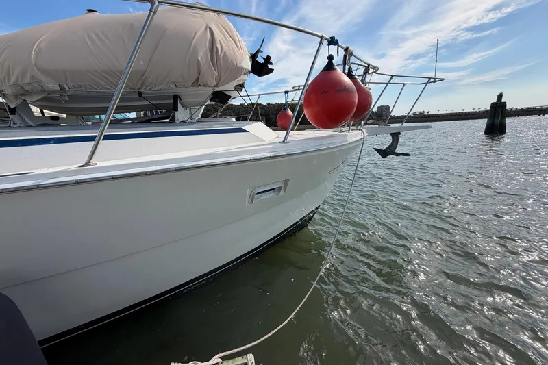 Slide: The Image of 1987 Viking 44 Motor Yacht with red buoys docked on calm water. - 7