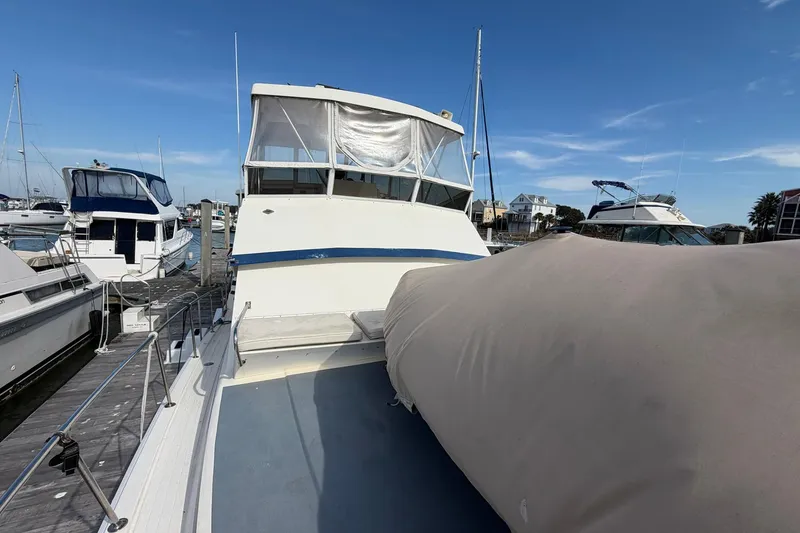 Slide: The Image of 1987 Viking 44 Motor Yacht docked at marina under clear blue sky. - 14