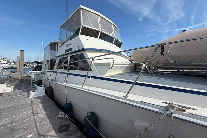 Slide: The Image of 1987 Viking 44 Motor Yacht docked at marina under clear blue sky. - 6
