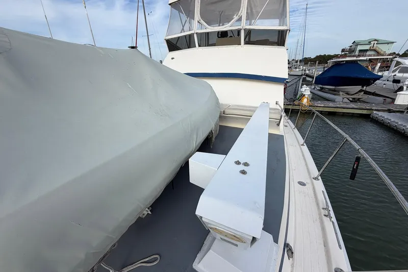 Slide: The Image of 1987 Viking 44 Motor Yacht docked, featuring covered deck and marina view. - 13