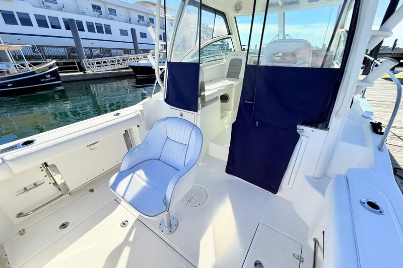 Slide: The Image of 2012 Boston Whaler 285 Conquest boat interior with seating and dockside view. - 10