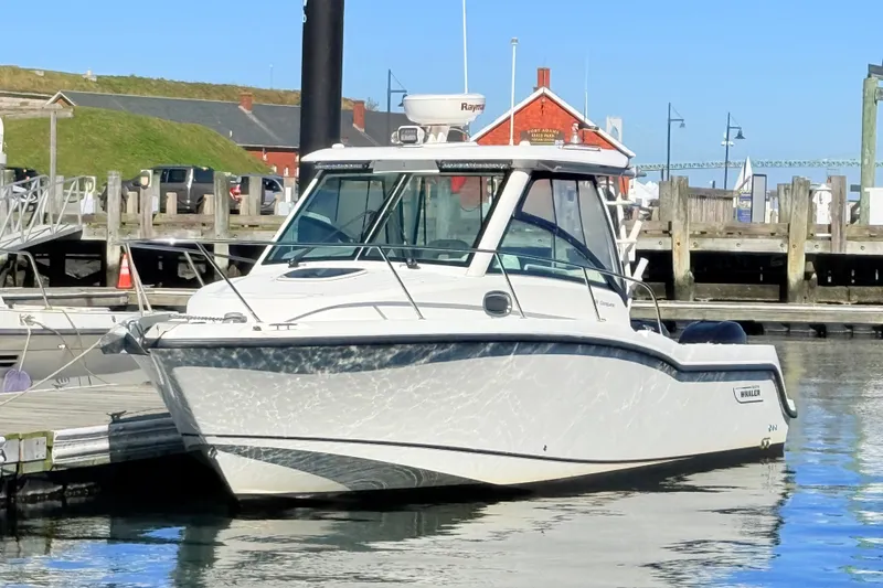 Slide: The Image of 2012 Boston Whaler 285 Conquest boat docked at a marina on a sunny day. - 3