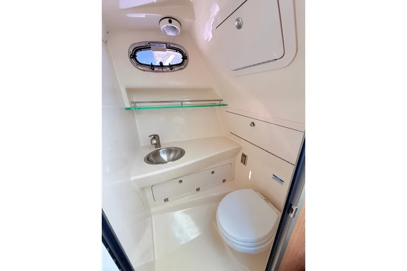 Slide: The Image of 2012 Boston Whaler 285 Conquest boat bathroom with sink, toilet, and storage. - 25