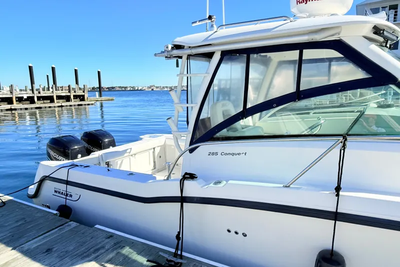 Slide: The Image of 2012 Boston Whaler 285 Conquest boat docked at marina with clear blue sky. - 7