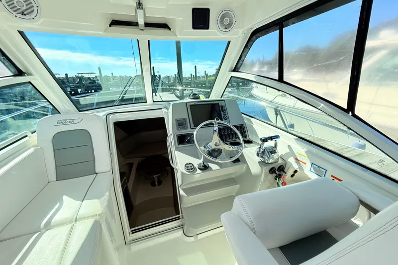 Slide: The Image of 2012 Boston Whaler 285 Conquest helm with modern controls and panoramic windows. - 16