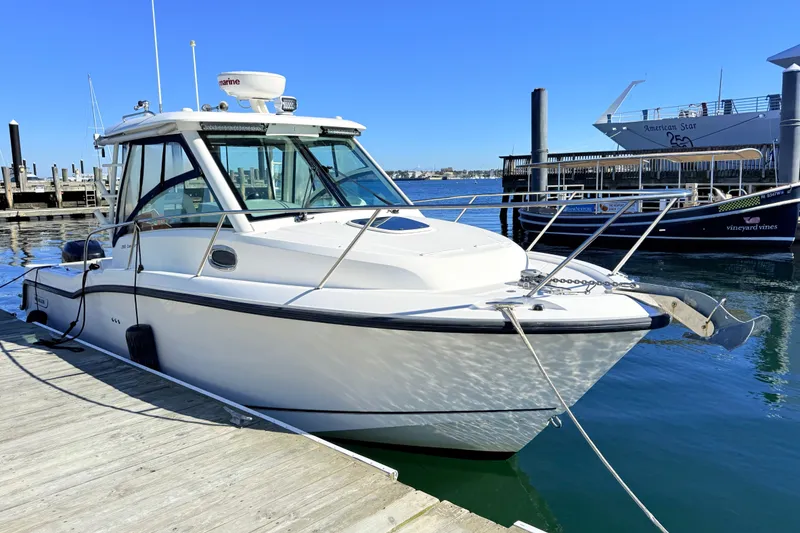Slide: The Image of 2012 Boston Whaler 285 Conquest docked at marina under clear blue sky. - 4