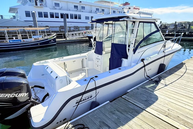 Slide: The Image of 2012 Boston Whaler 285 Conquest docked, featuring sleek design and powerful Mercury engines. - 6