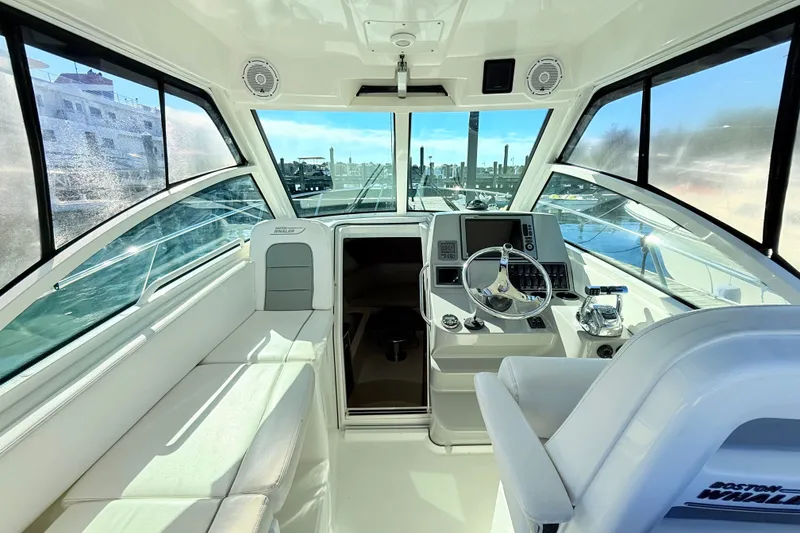 Slide: The Image of Interior of 2012 Boston Whaler 285 Conquest boat, featuring helm and seating area. - 14