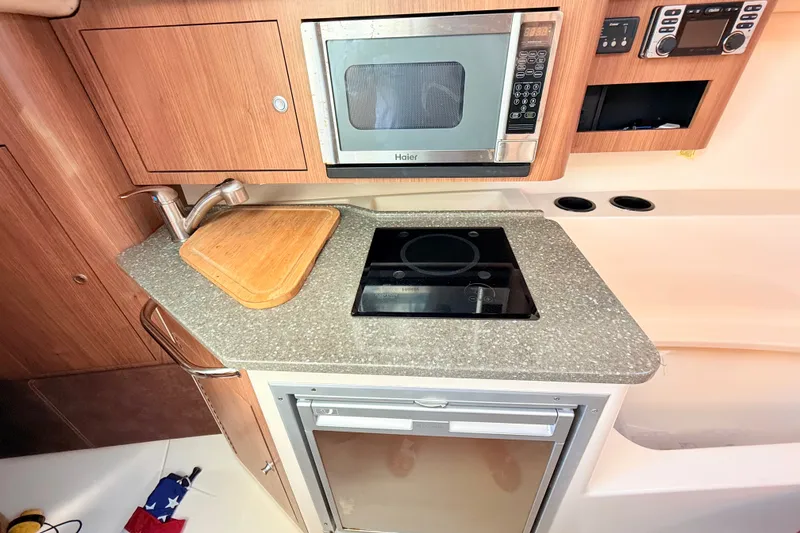 Slide: The Image of 2012 Boston Whaler 285 Conquest galley with microwave, stove, and sink. - 22