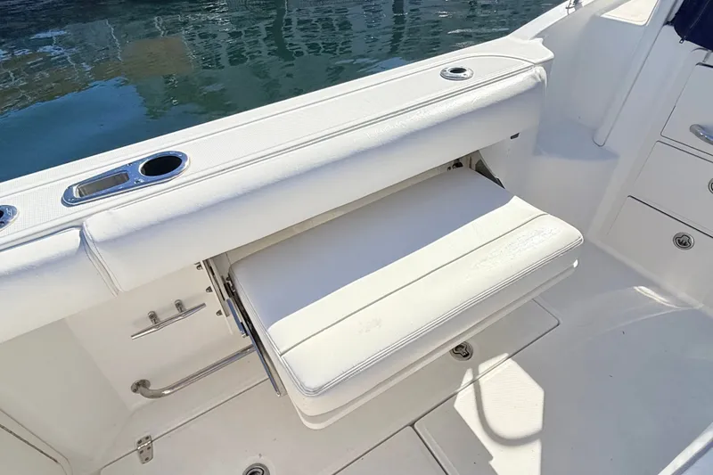 Slide: The Image of 2012 Boston Whaler 285 Conquest boat interior with foldable seat and cup holders. - 13