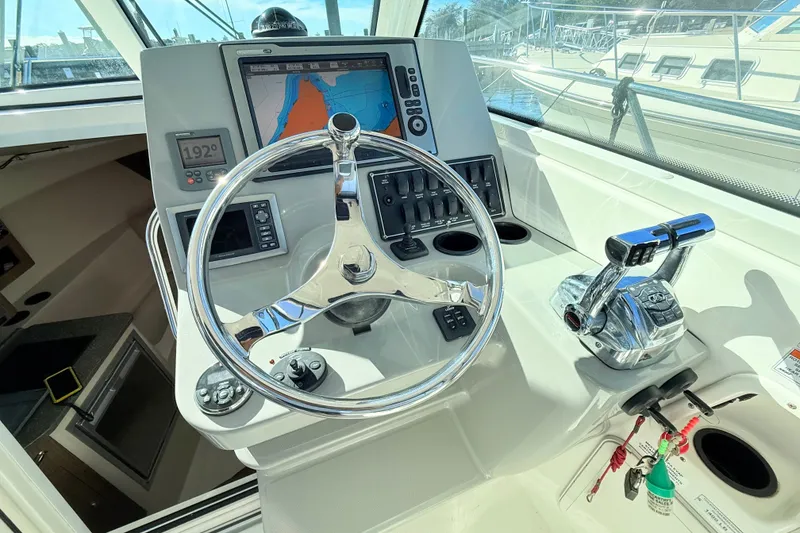 Slide: The Image of Control panel of a 2012 Boston Whaler 285 Conquest boat with steering wheel and navigation display. - 17