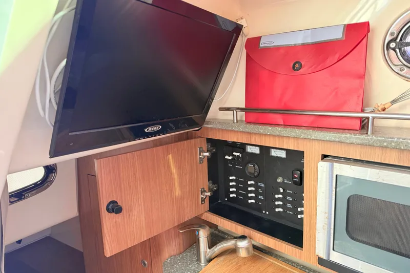 Slide: The Image of Interior of 2012 Boston Whaler 285 Conquest with TV, control panel, and microwave. - 23