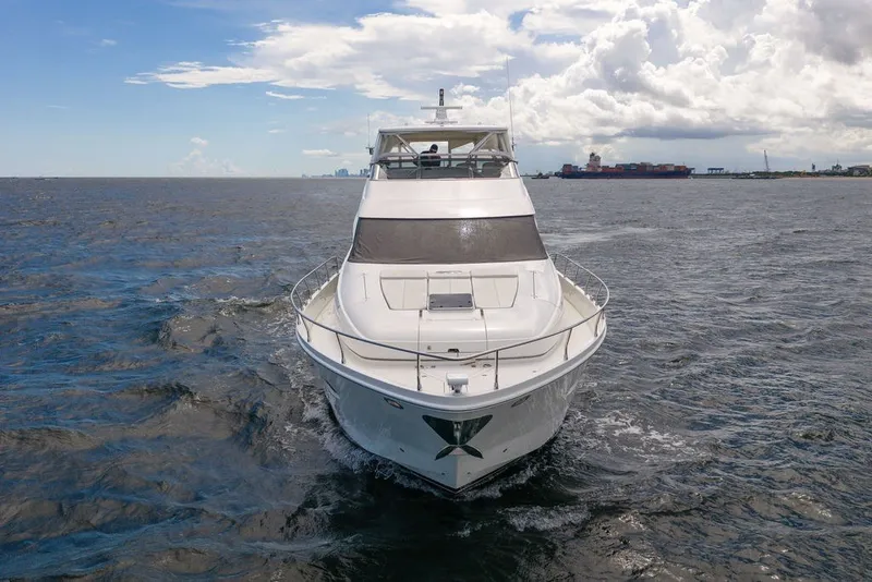 Slide: The Image of Front view of a 2007 Marquis 65 yacht cruising on open water under a partly cloudy sky. - 2