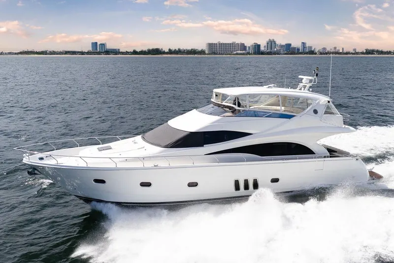 Slide: The Image of Luxury 2007 Marquis 65 yacht cruising on open water with city skyline backdrop. - 1