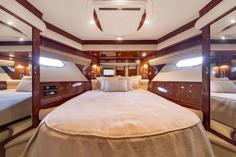 Slide: The Image of Luxurious 2007 Marquis 65 yacht bedroom with elegant wood finishes and plush bedding. - 51