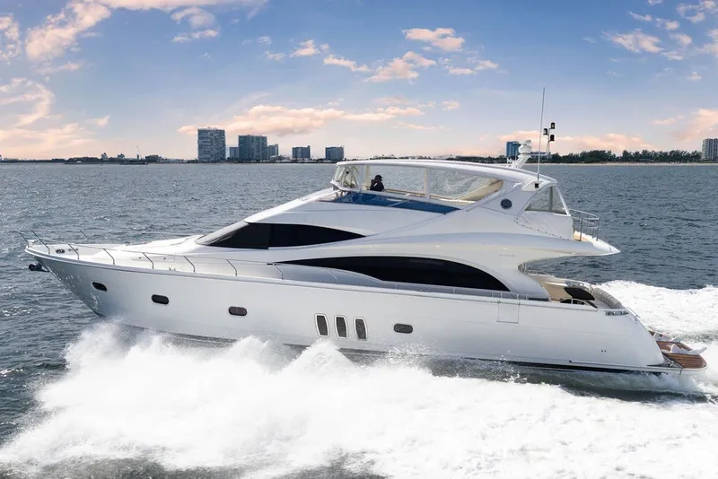 Slide: The Image of 2007 Marquis 65 yacht cruising on open water with city skyline in background. - 11