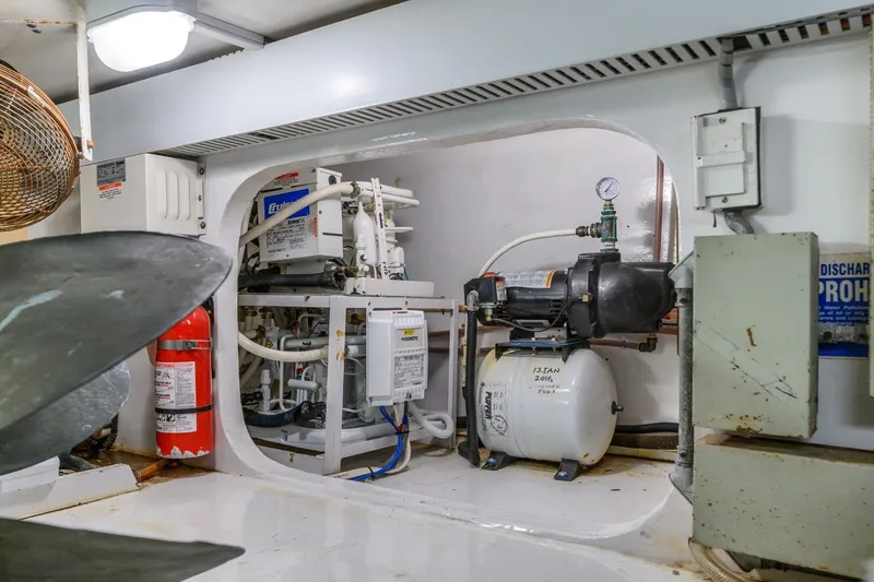 Slide: The Image of Engine room of 1999 Viking 60 Cockpit Motor Yacht with equipment and fire extinguisher. - 43