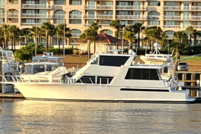 The Image of 1999 Viking 60 Cockpit Motor Yacht docked at marina with waterfront buildings. - 1